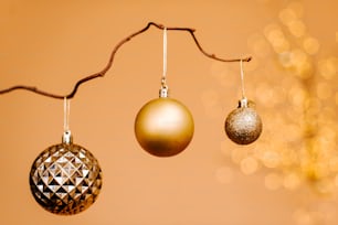 Tre ornamenti natalizi appesi a un ramo di un albero