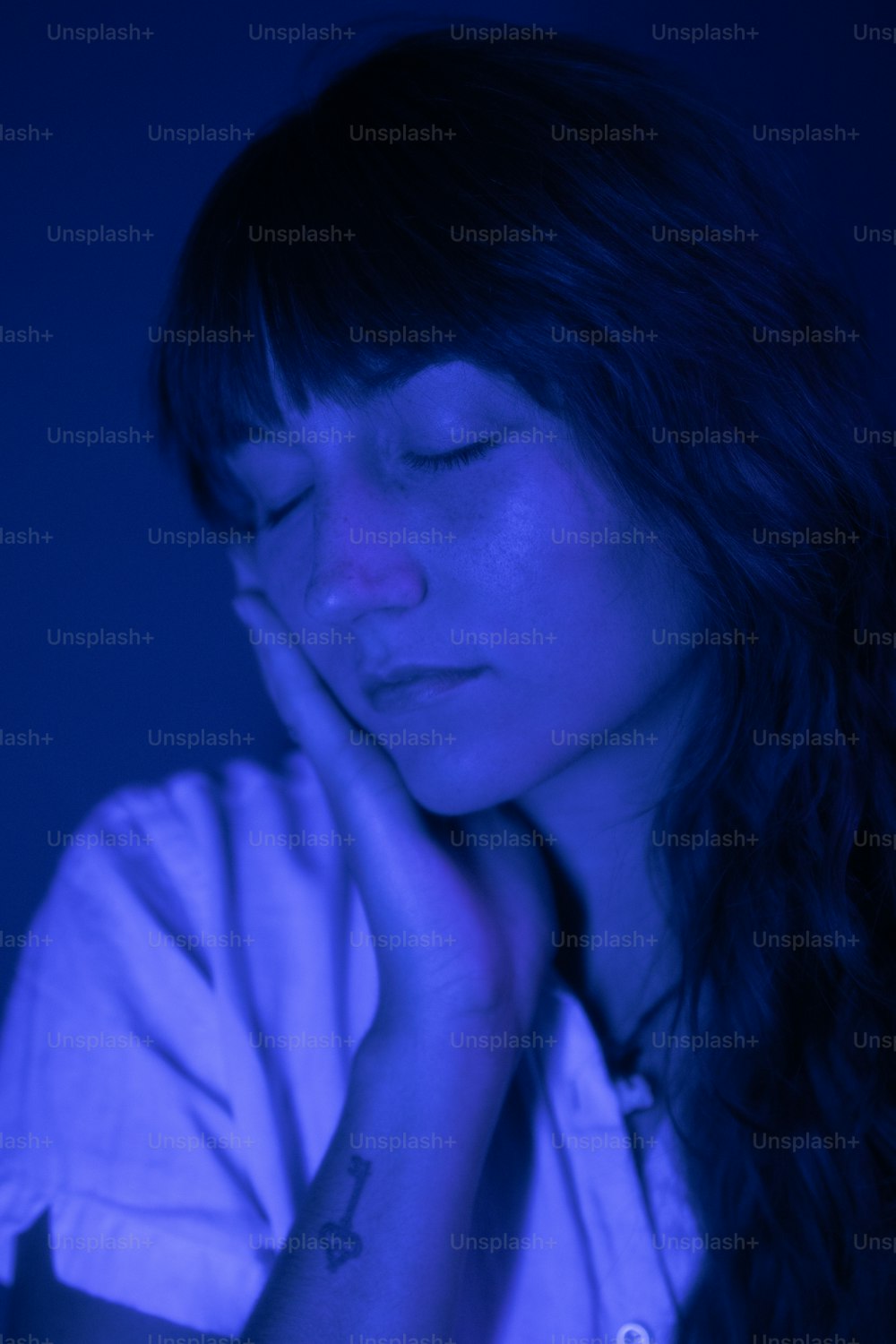 a woman with her eyes closed in a dark room