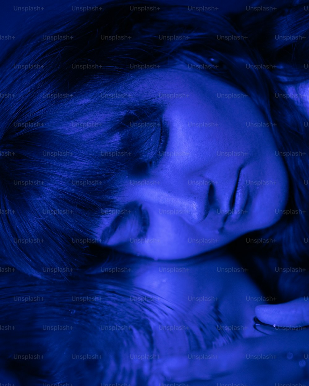 a woman laying in bed with her eyes closed