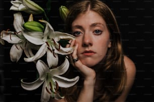 a woman is holding a bunch of white flowers