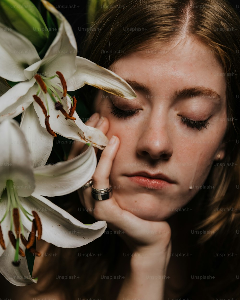 a woman holding a bouquet of white flowers