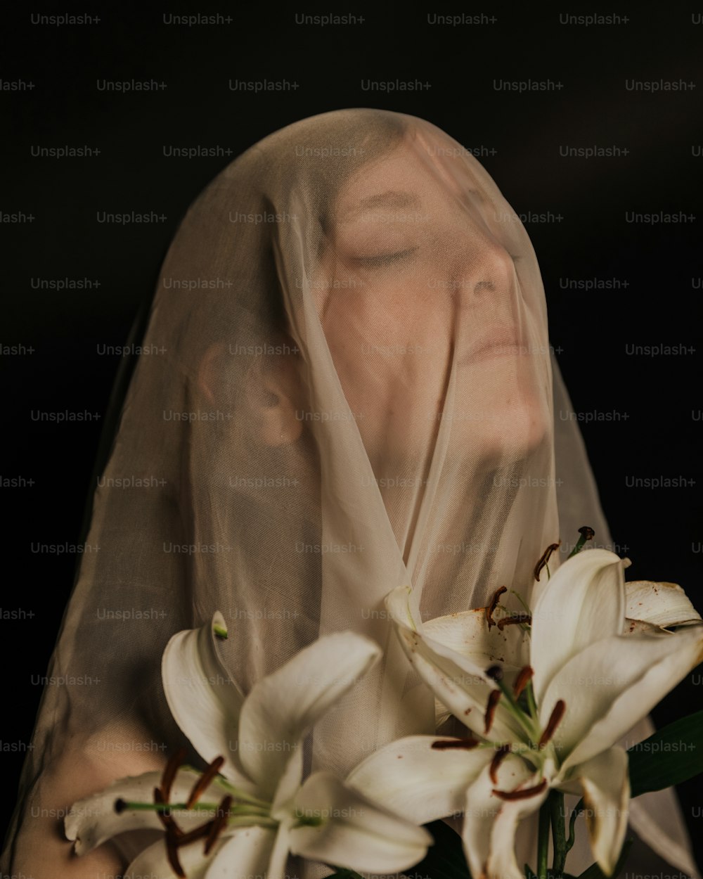 uma mulher usando um véu e segurando um buquê de flores