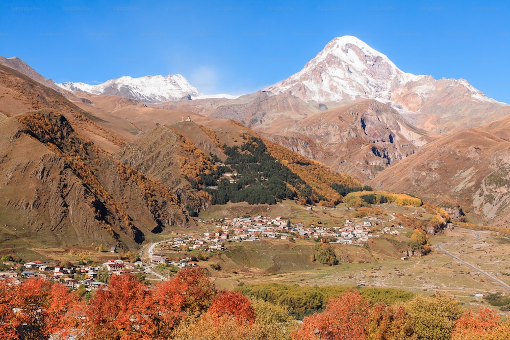 Una veduta di un villaggio in una valle con le montagne sullo sfondo