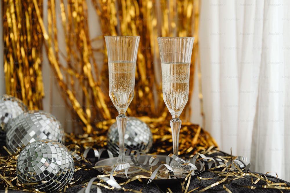 two champagne flutes sitting on top of a table
