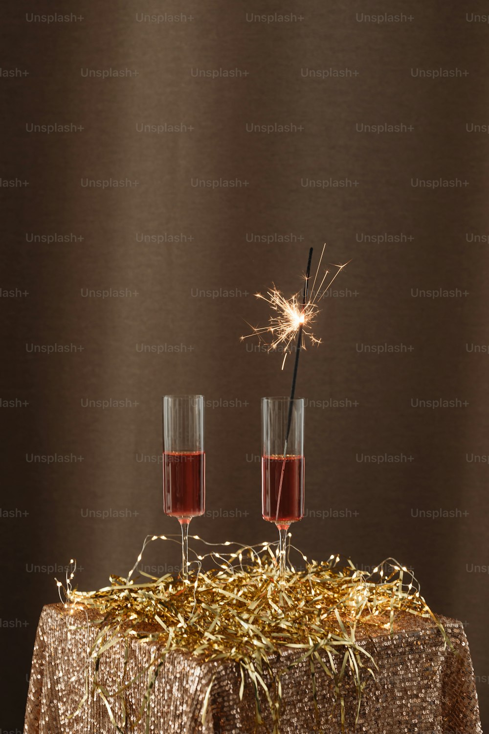 a table topped with two glasses of wine and a sparkler