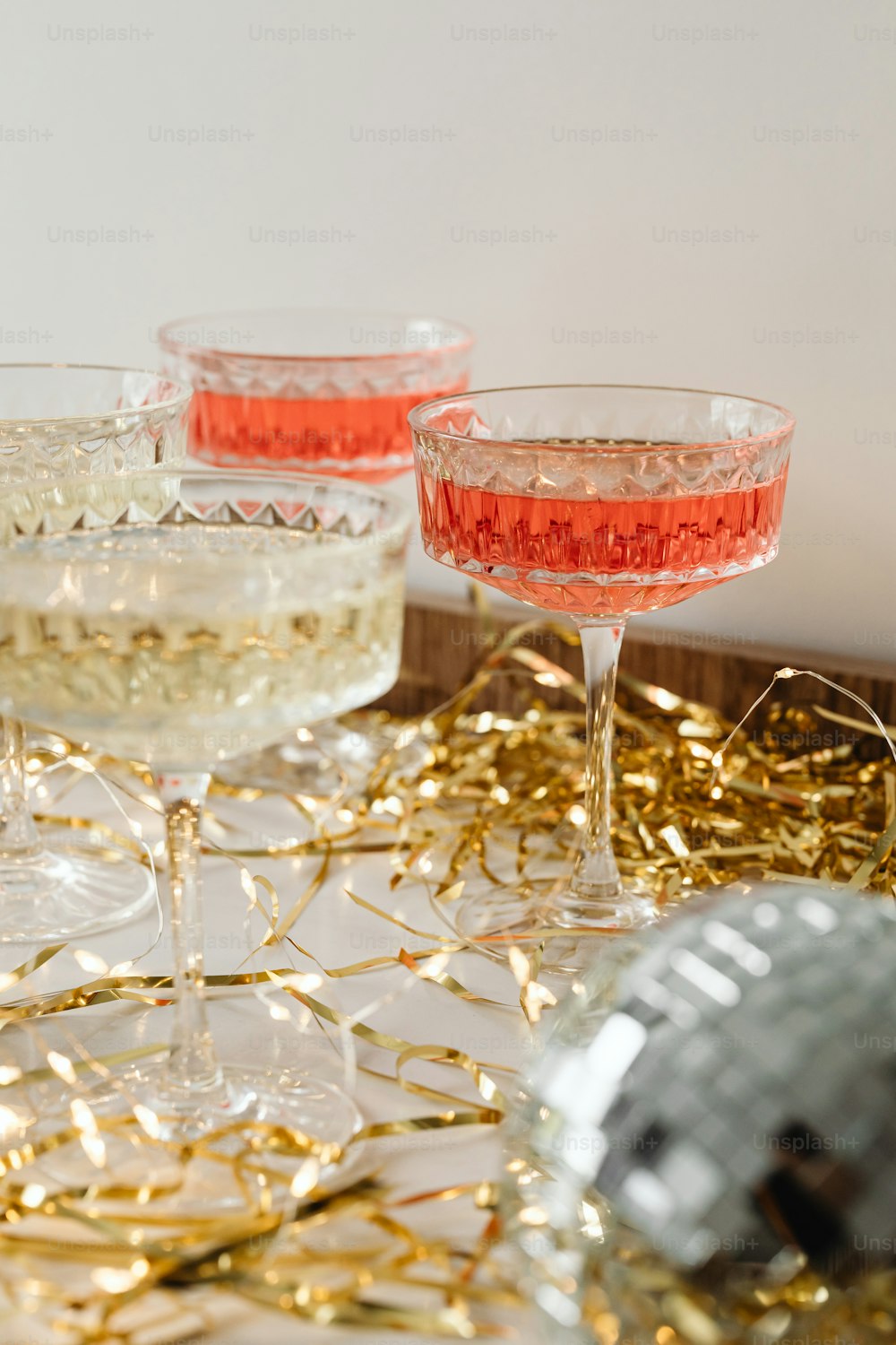 three glasses of champagne on a tray with confetti