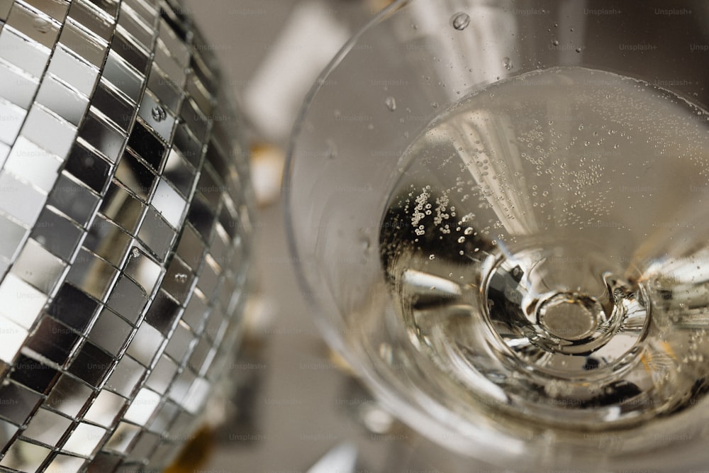 a close up of a wine glass with a disco ball in the background