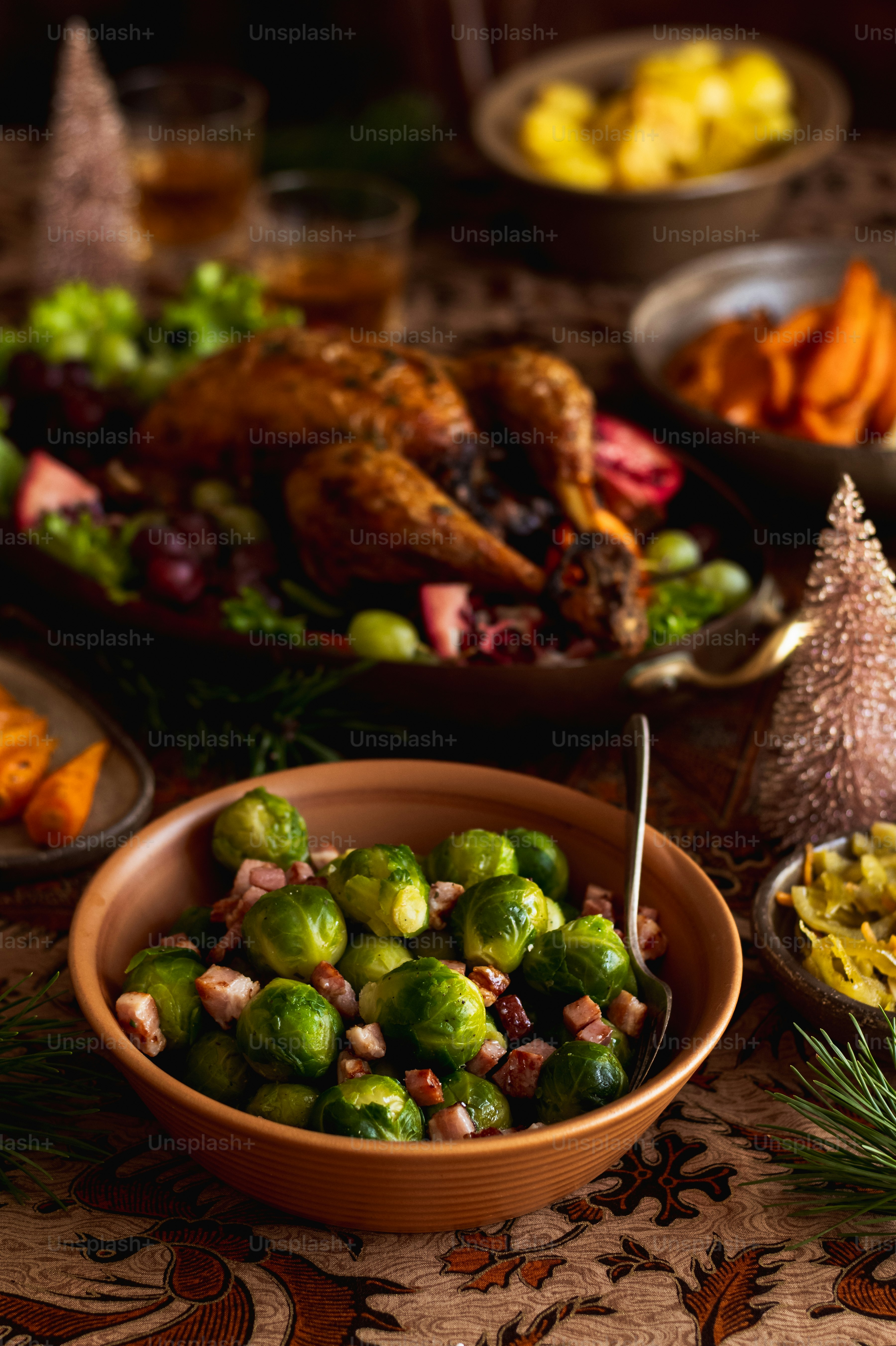 a bowl of brussel sprouts next to a platter of vegetables