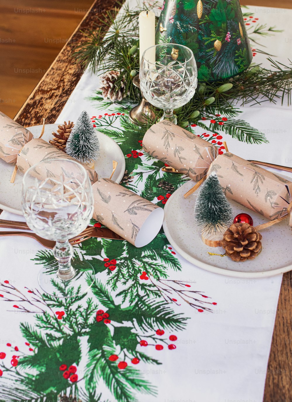 a christmas table setting with pine cones and candles