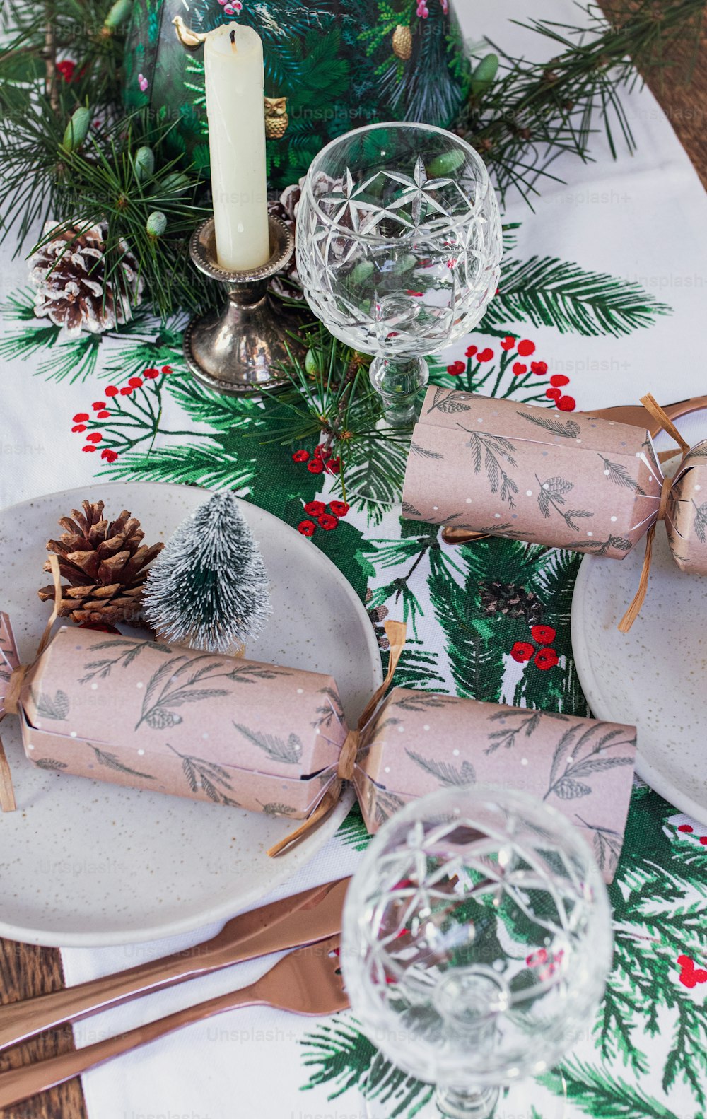 a table set for christmas with pine cones and napkins