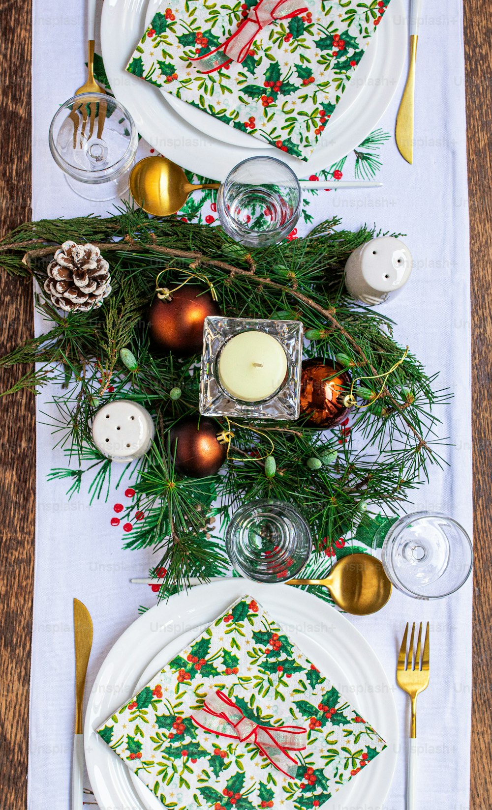 a table set for christmas dinner with place settings