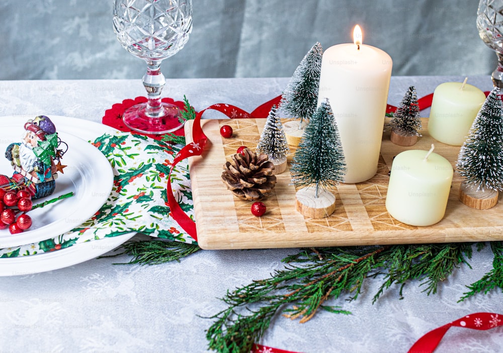 a wooden tray topped with candles and christmas decorations