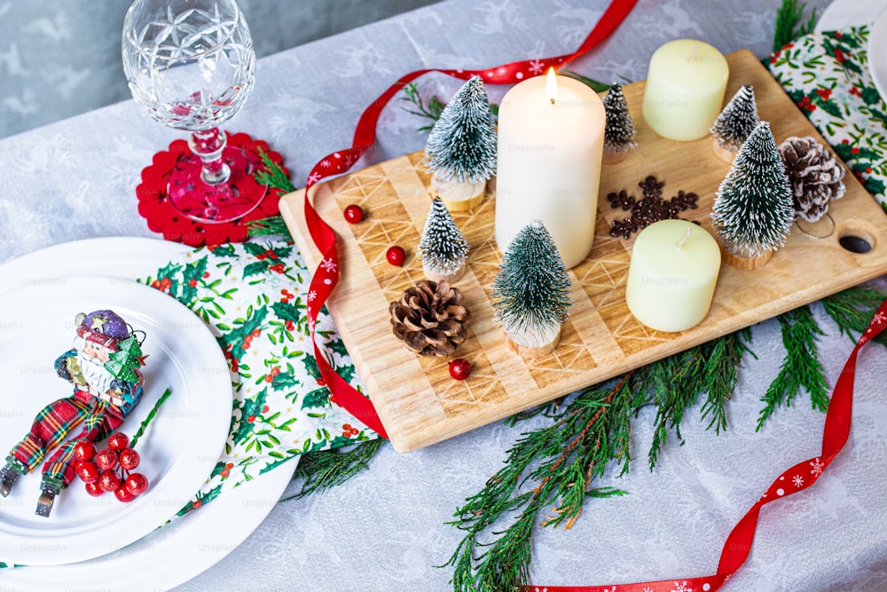 a tray with candles and pine cones on a table