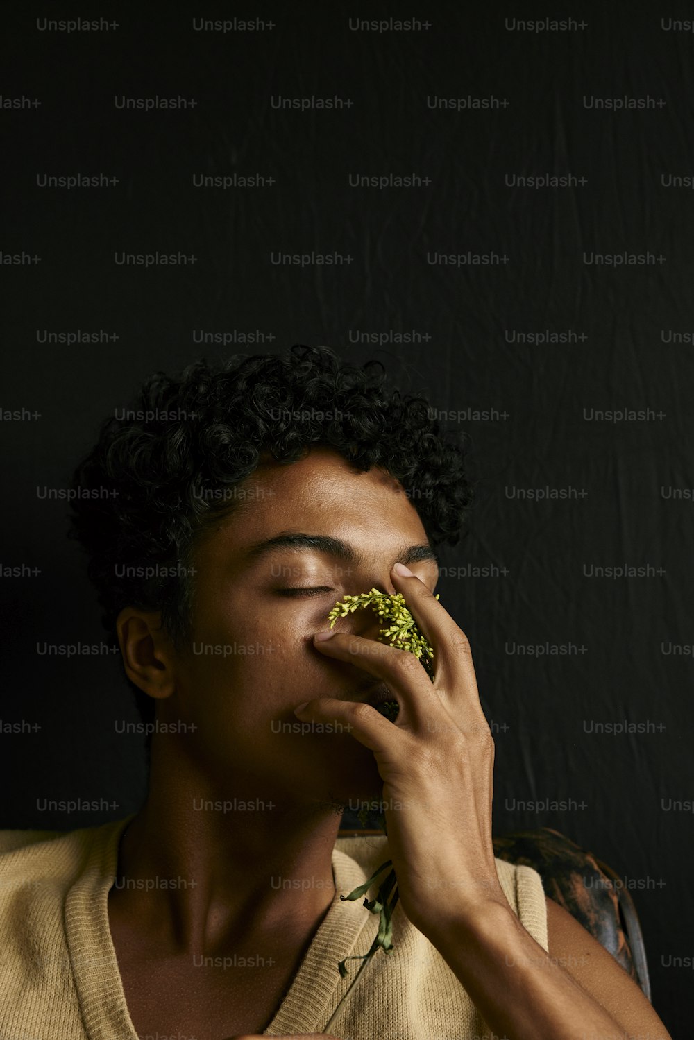 um homem comendo um pedaço de brócolis de olhos fechados