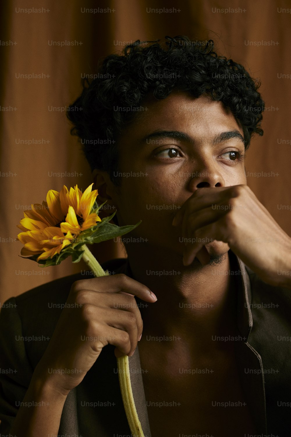 얼굴 앞에 꽃을 들고 있는 남자