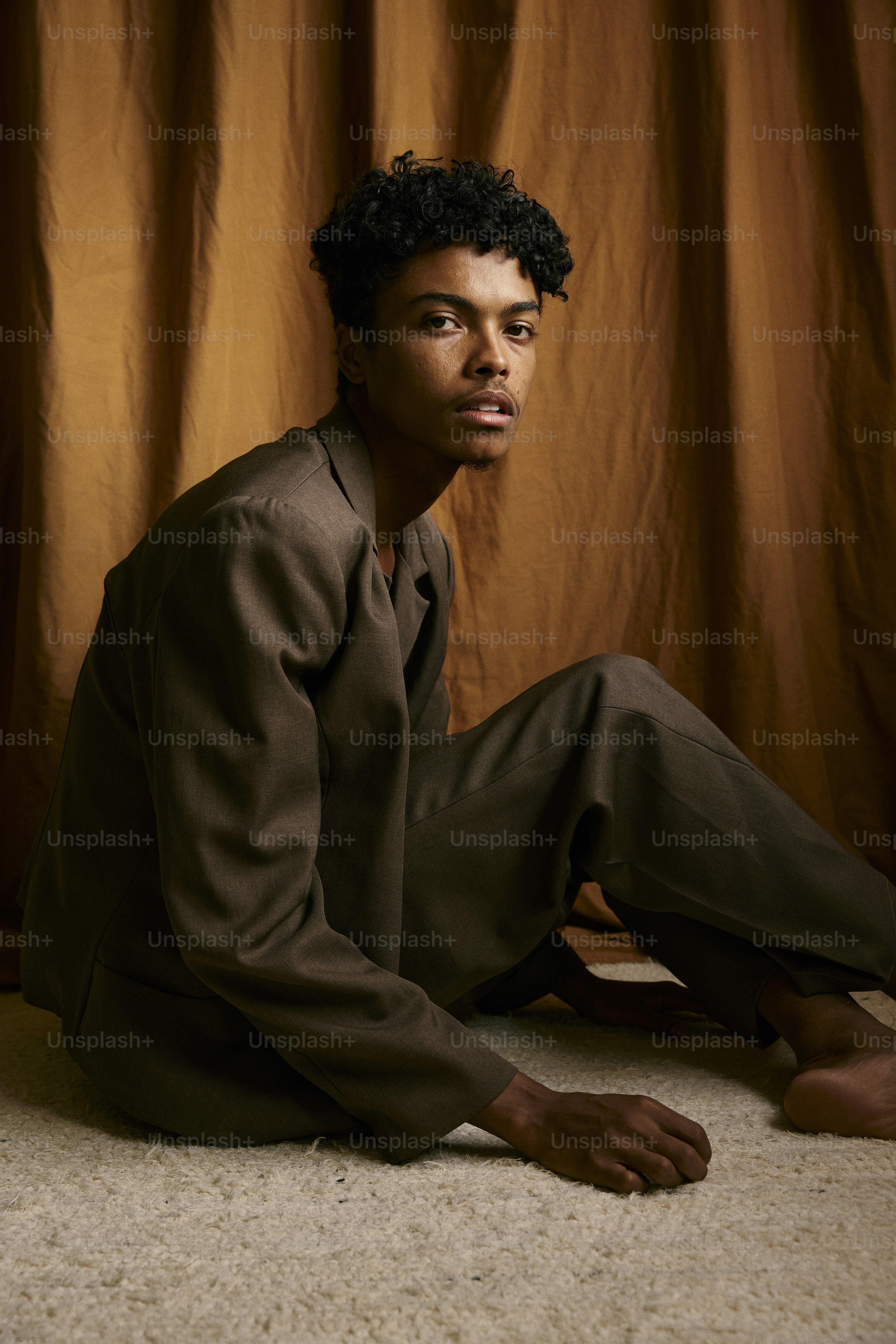 a man sitting on the floor in a suit