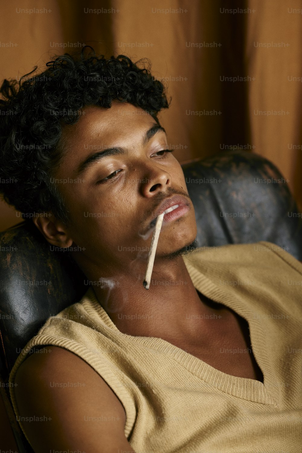 a man sitting in a chair with a cigarette in his mouth