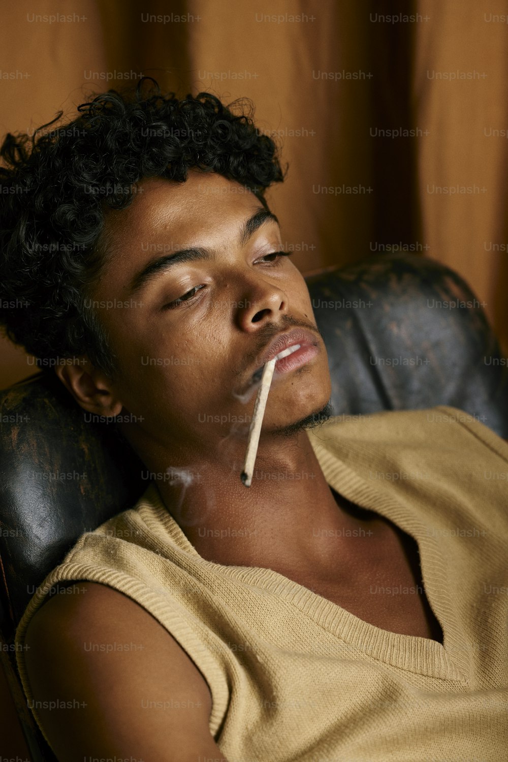 Ein Mann sitzt auf einem Stuhl mit einer Zigarette im Mund