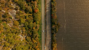 an aerial view of a road next to a body of water