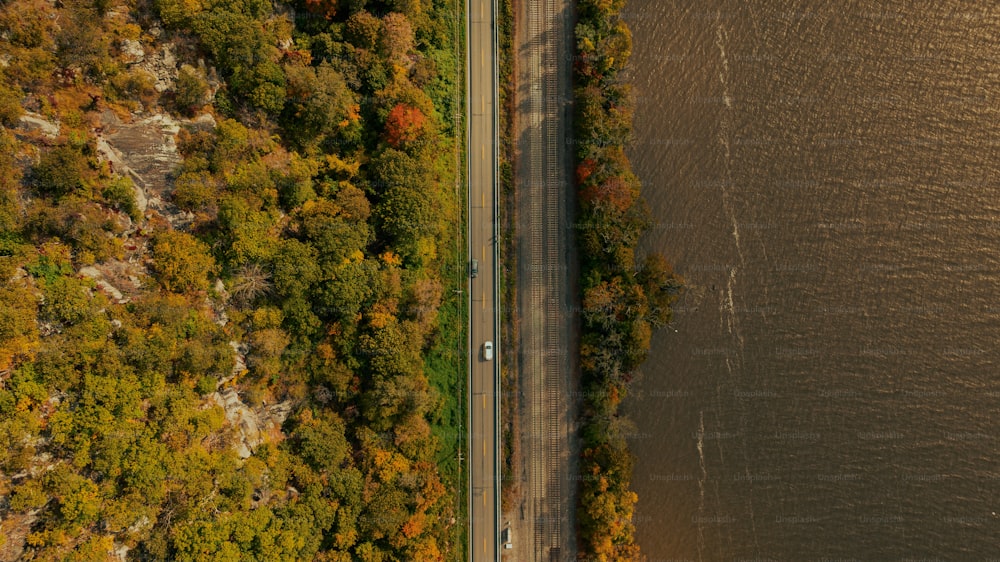 an aerial view of a road next to a body of water