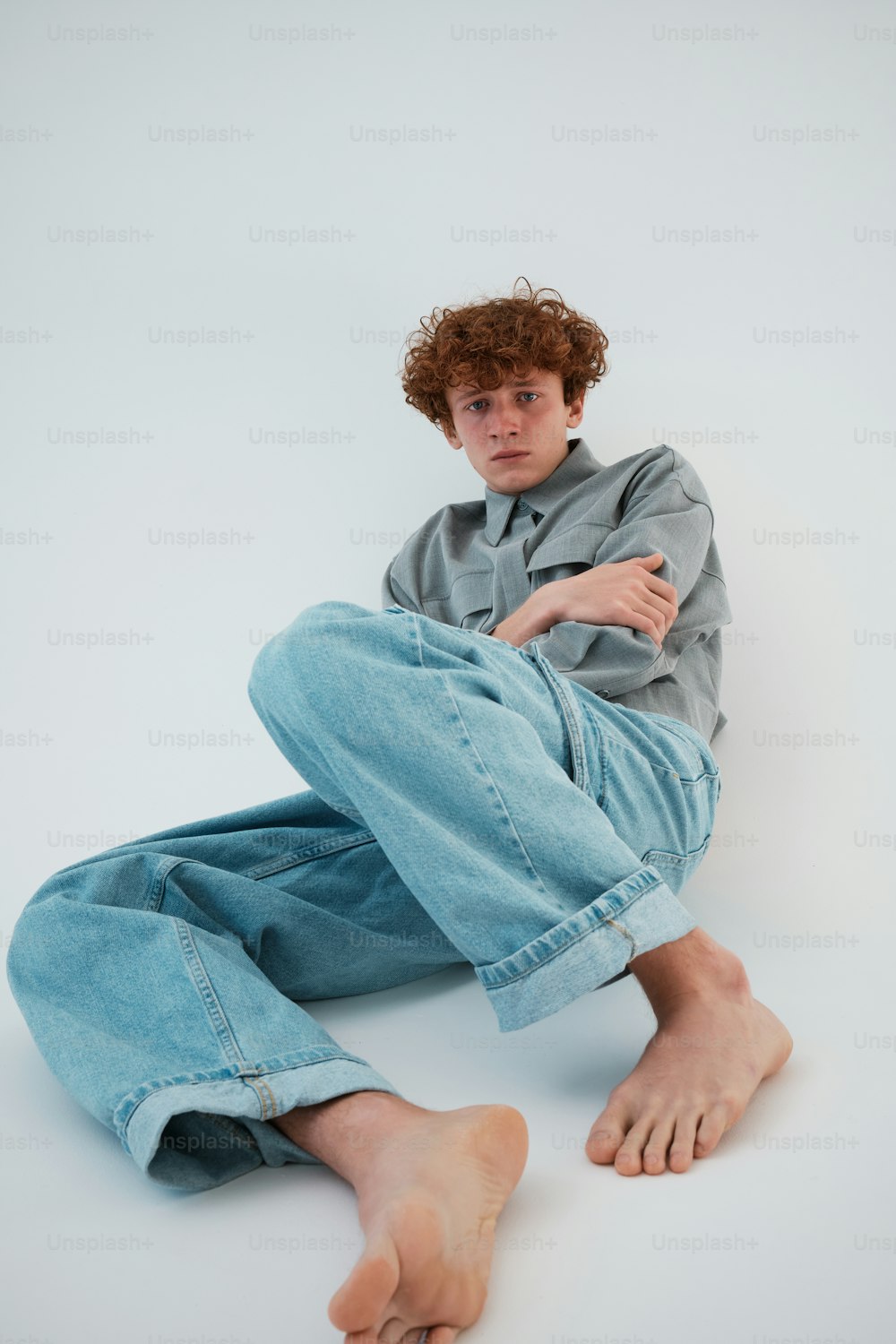Ein junger Mann sitzt mit gekreuzten Beinen auf dem Boden