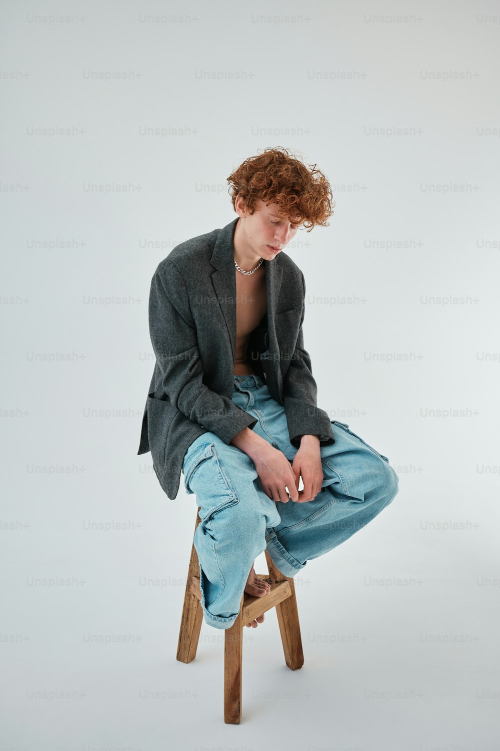 a man sitting on top of a wooden stool