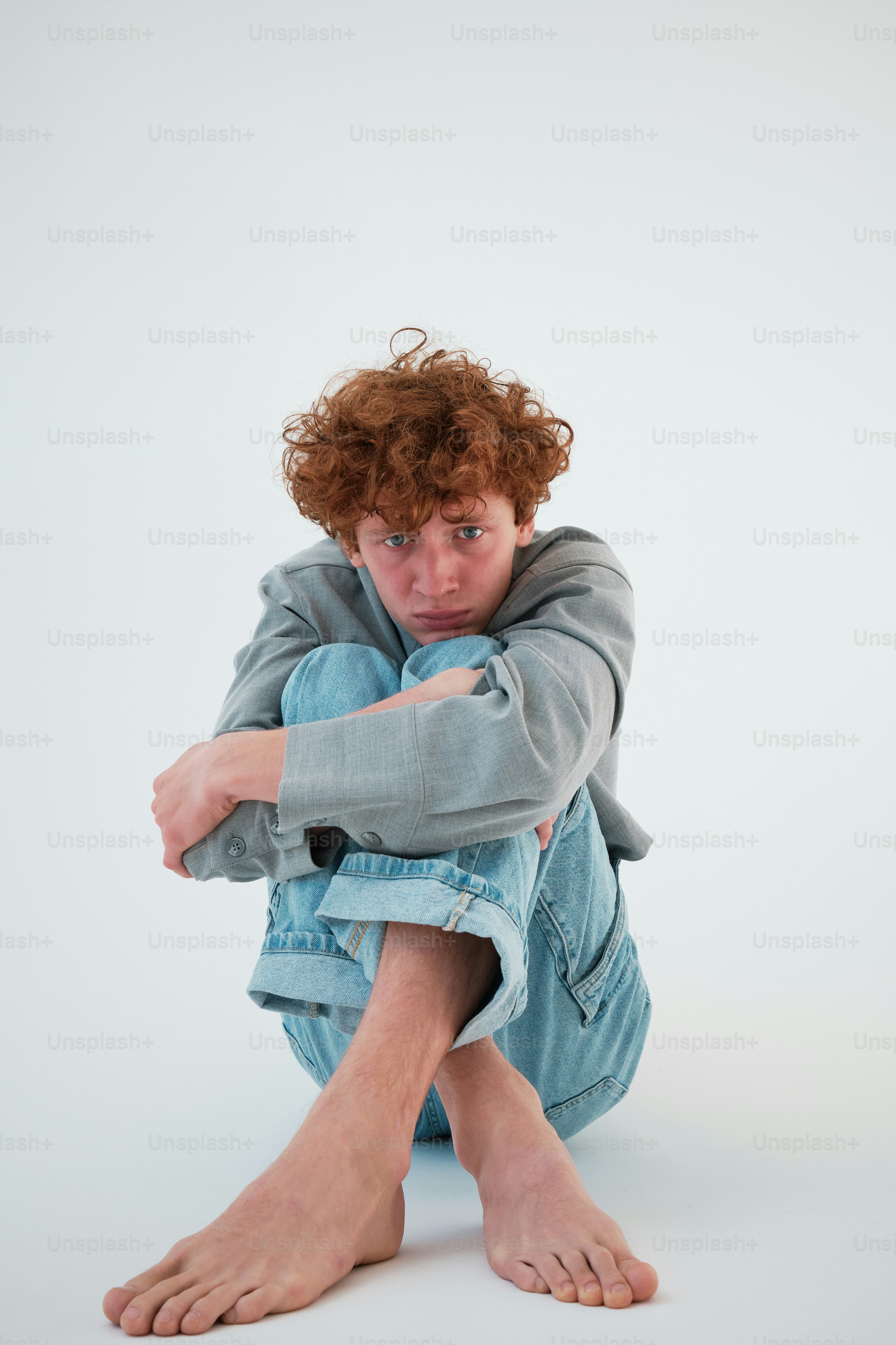 a man sitting on the ground with his arms crossed