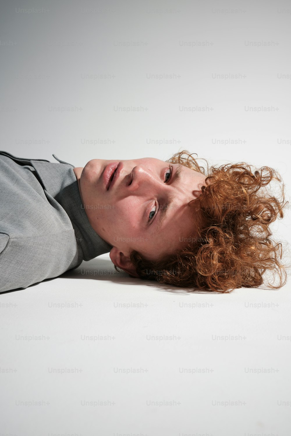 a woman with curly hair laying on the ground