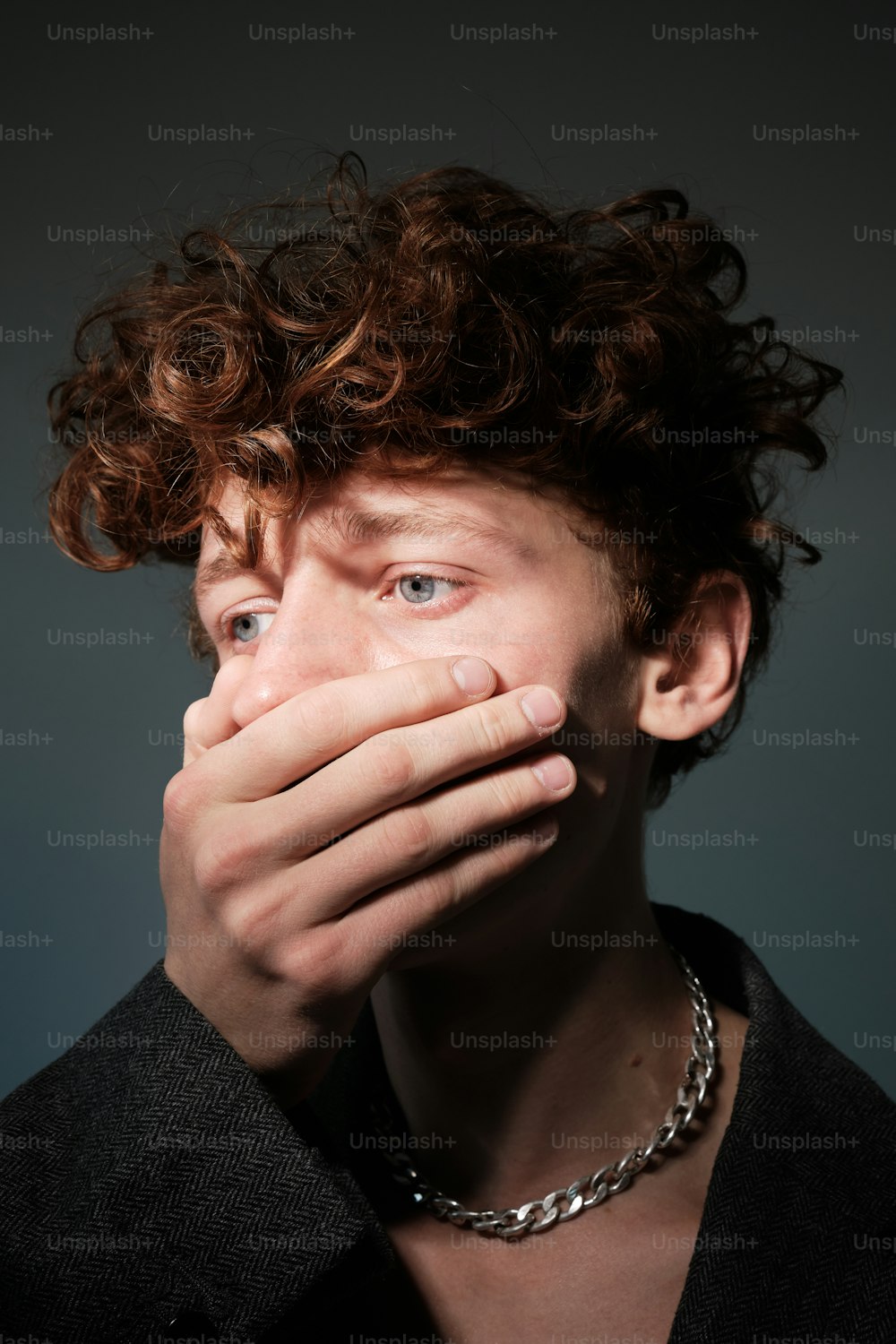 a man covering his mouth with his hands