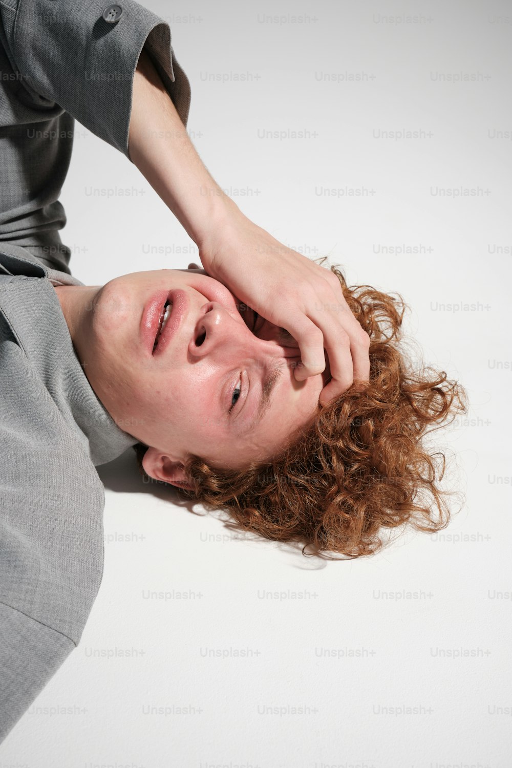 a man laying on the ground with his hands on his head