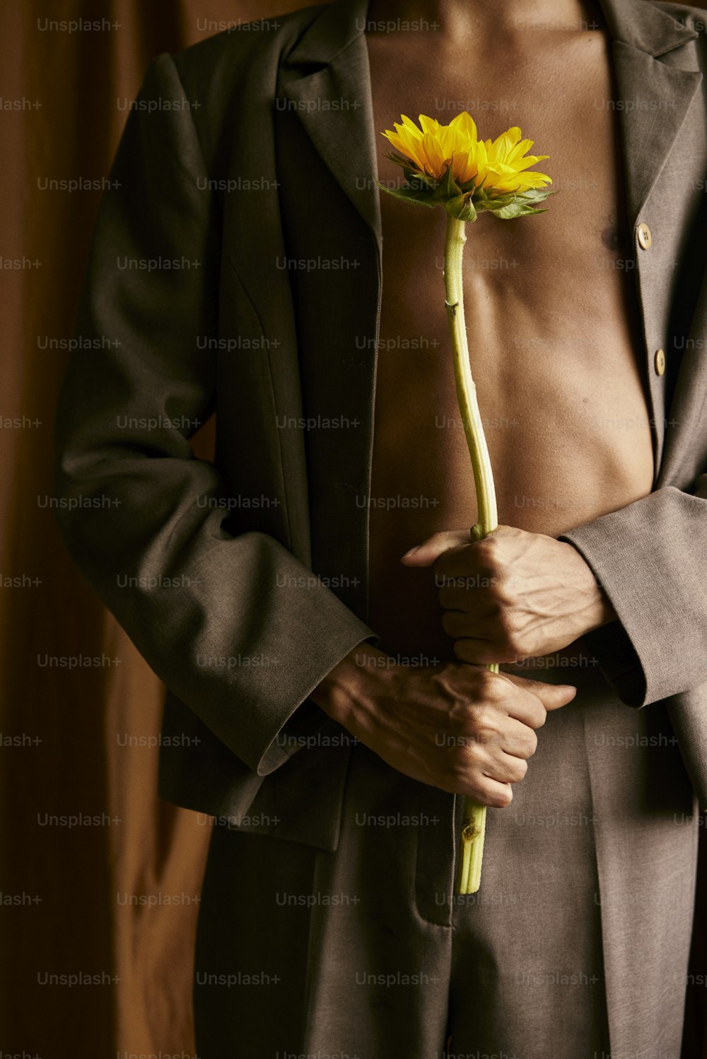 黄色い花を持つスーツを着た男