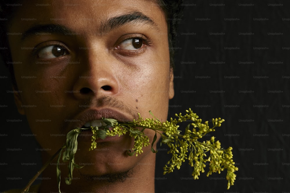 a man with a plant in his mouth