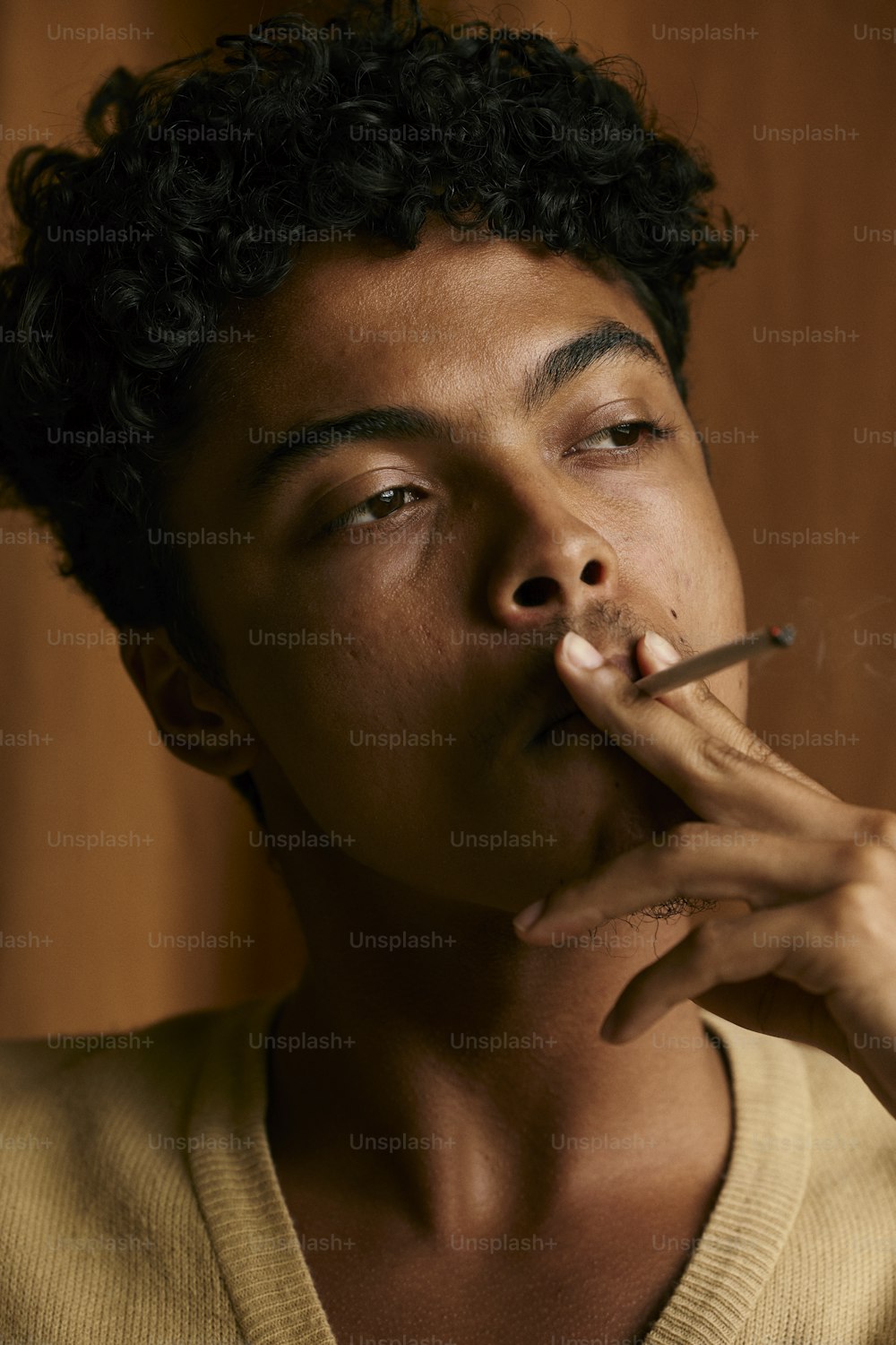 a man smoking a cigarette with his eyes closed