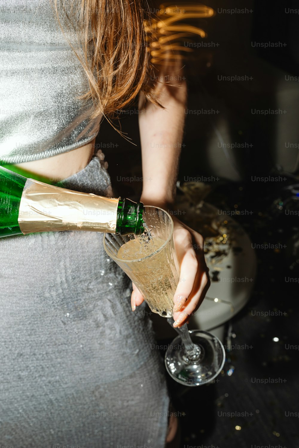 a woman pouring champagne into a wine glass
