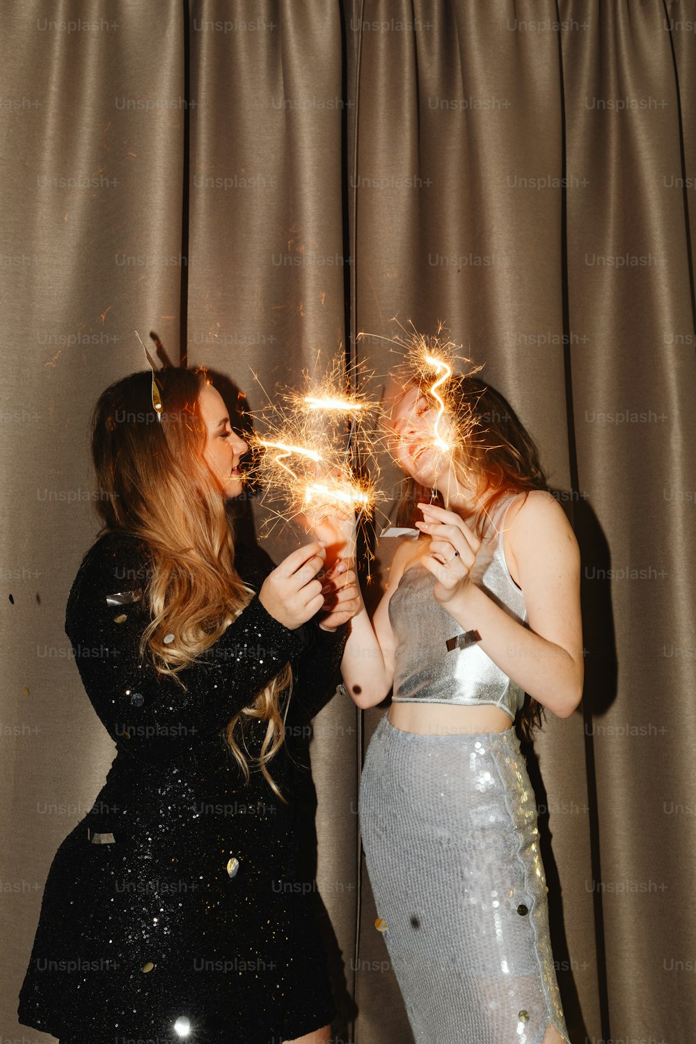 two women are holding sparklers in their hands