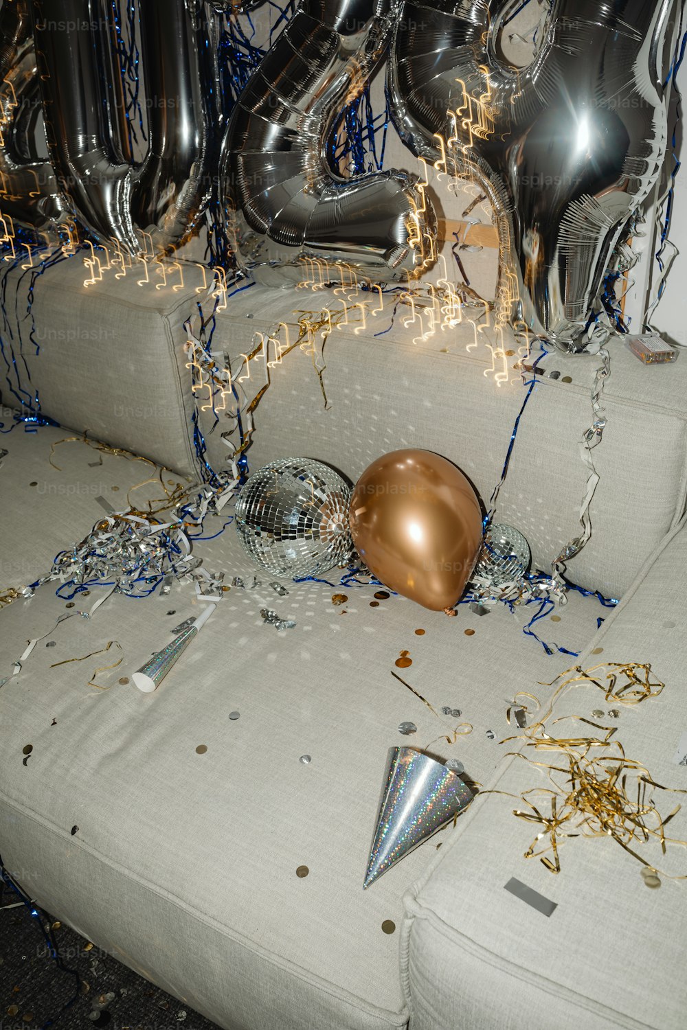 a bunch of balloons and confetti on a couch