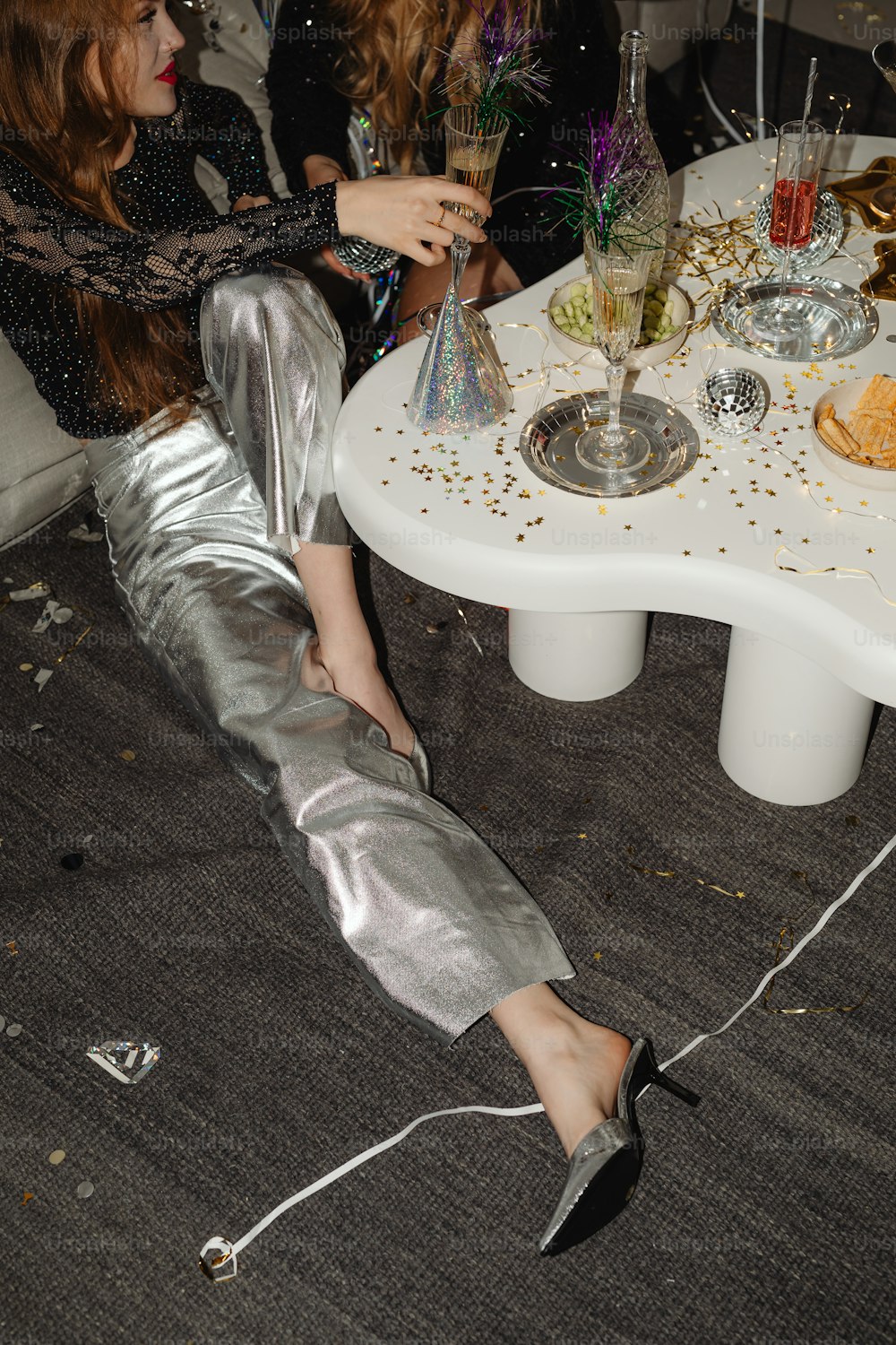 a woman laying on the floor next to a table