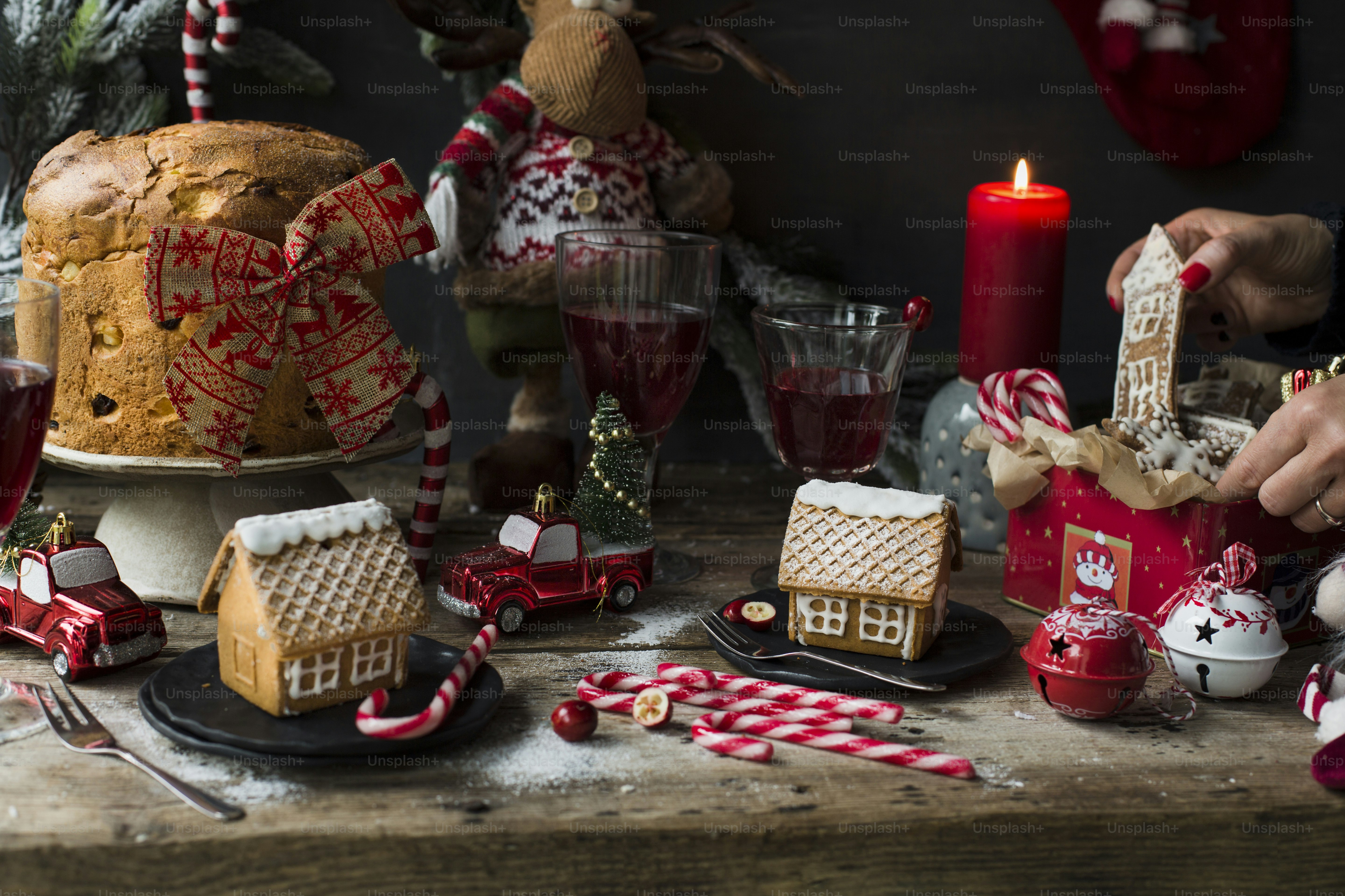 eine Person, die einen Tisch mit Lebkuchenhäusern dekoriert