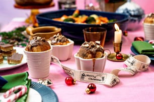 a table topped with plates and cups filled with desserts