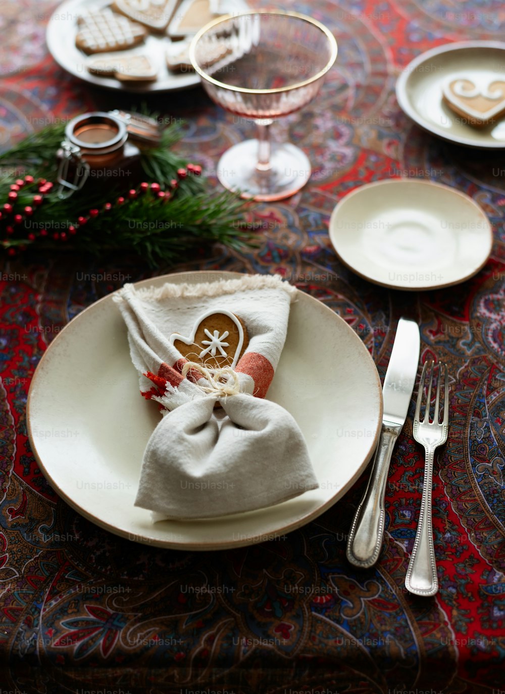 a table set for christmas dinner with silverware and cookies