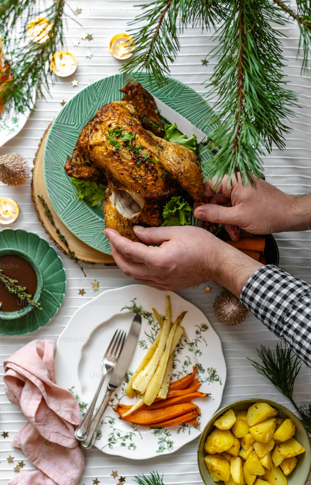a person holding a turkey over a plate of food