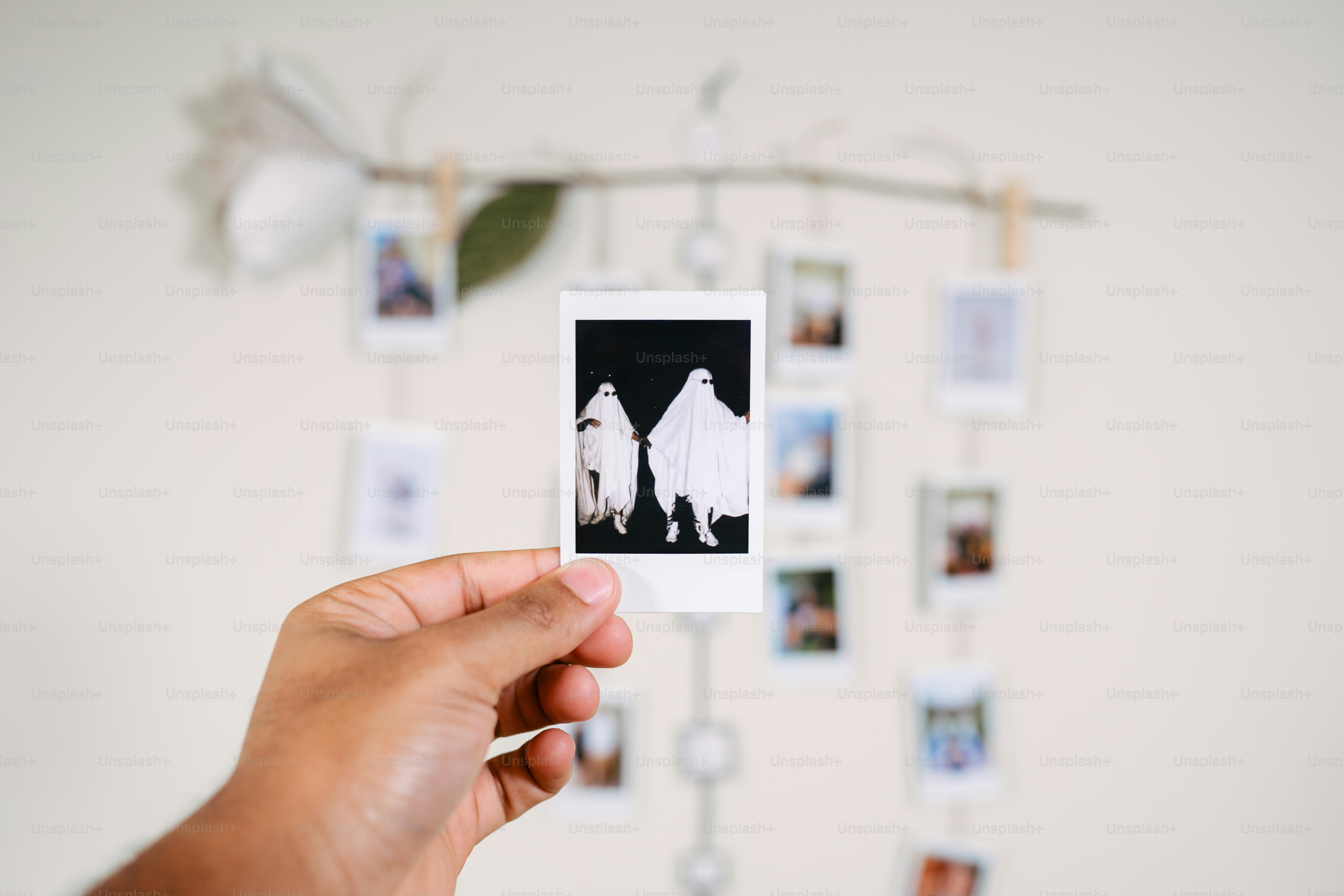 a person holding up a polaroid with pictures on it