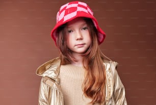 a little girl wearing a red and white hat