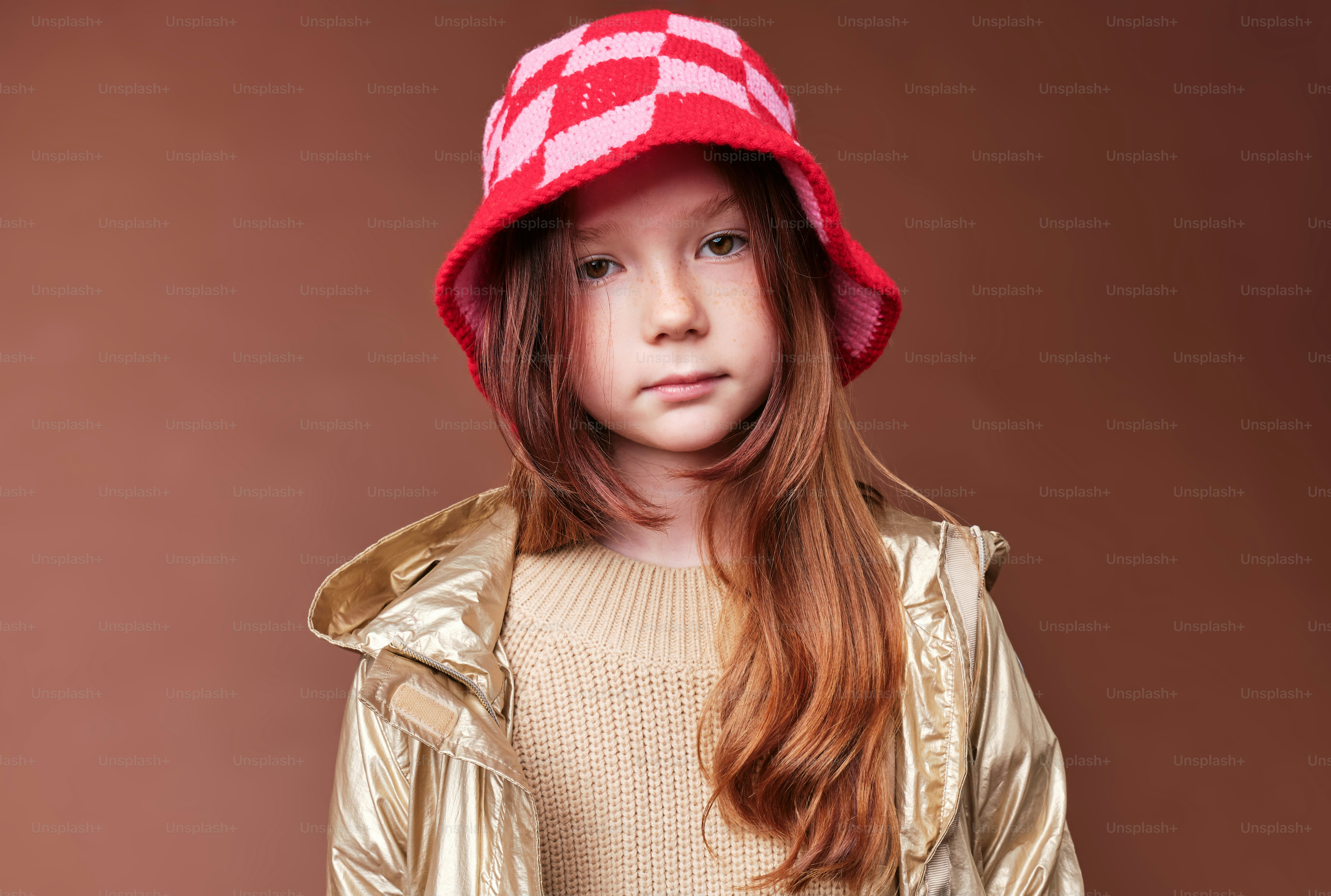 A girl in autumn clothes on studio background in warm color scheme