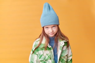 uma jovem vestindo um chapéu azul e jaqueta verde