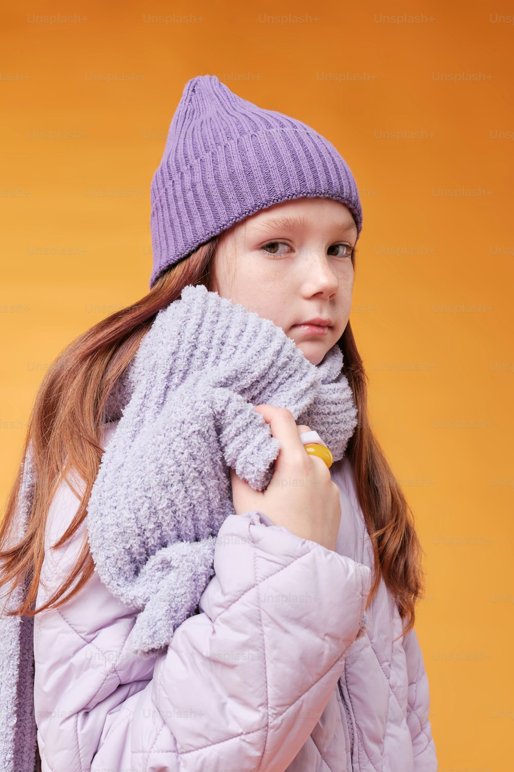 a young girl wearing a purple coat and a purple hat