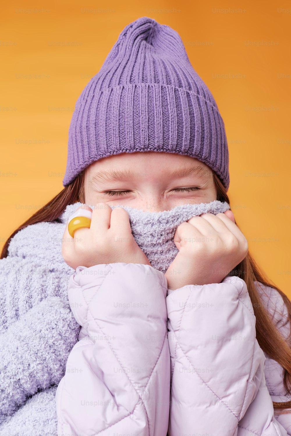 a young girl covers her face with her hands