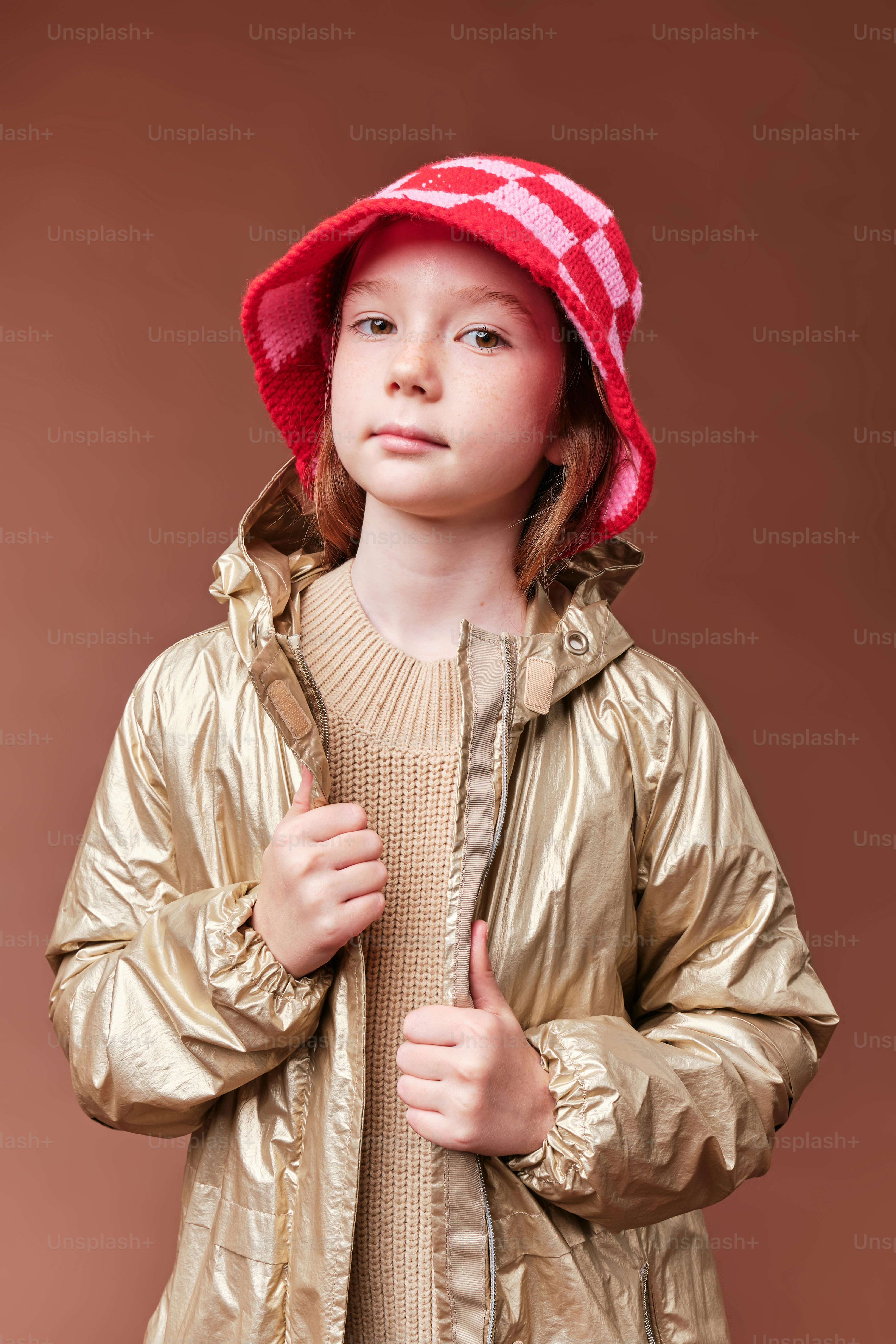 A girl in autumn clothes on studio background in warm color scheme