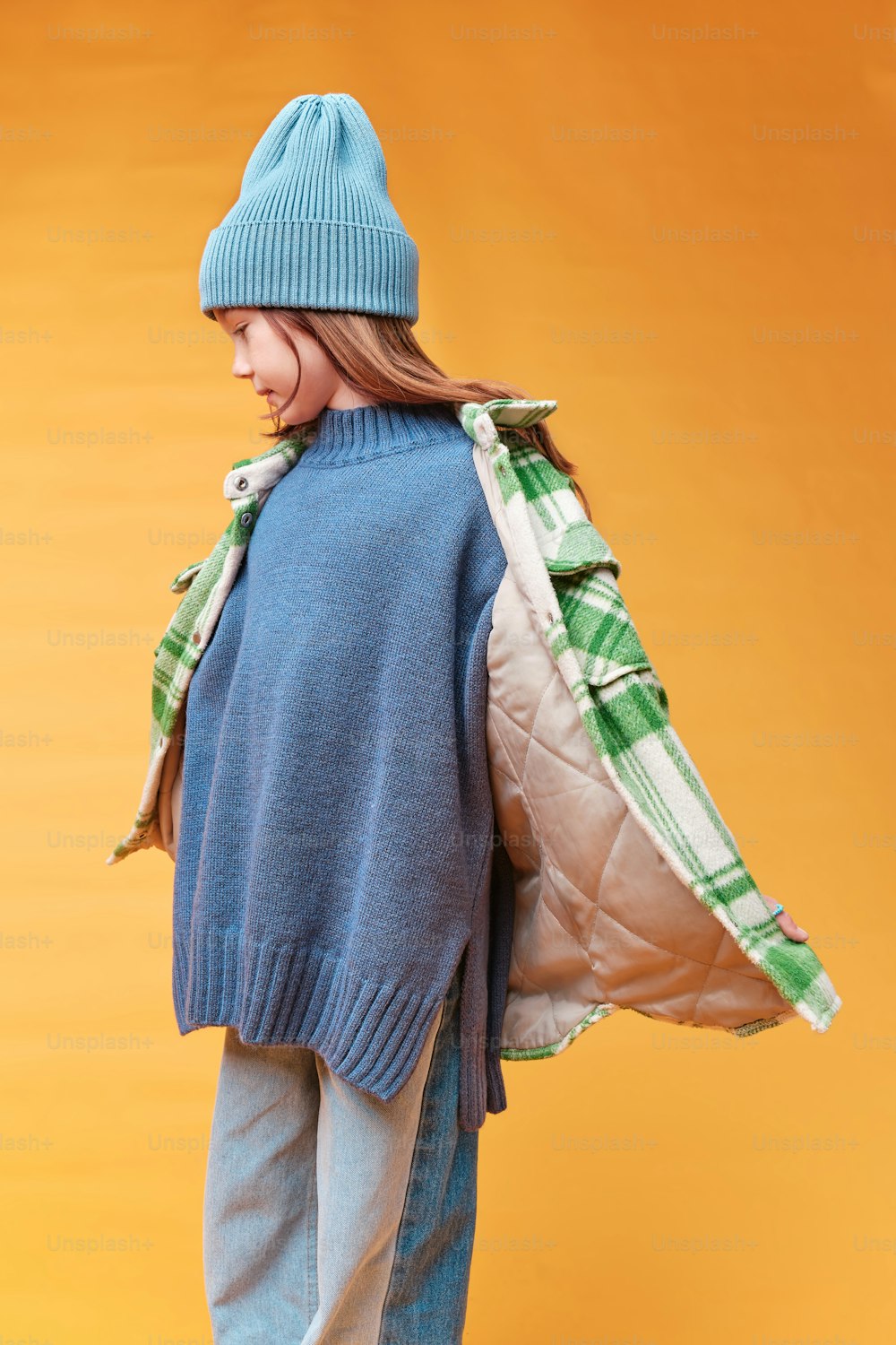 a doll wearing a blue sweater and a blue hat