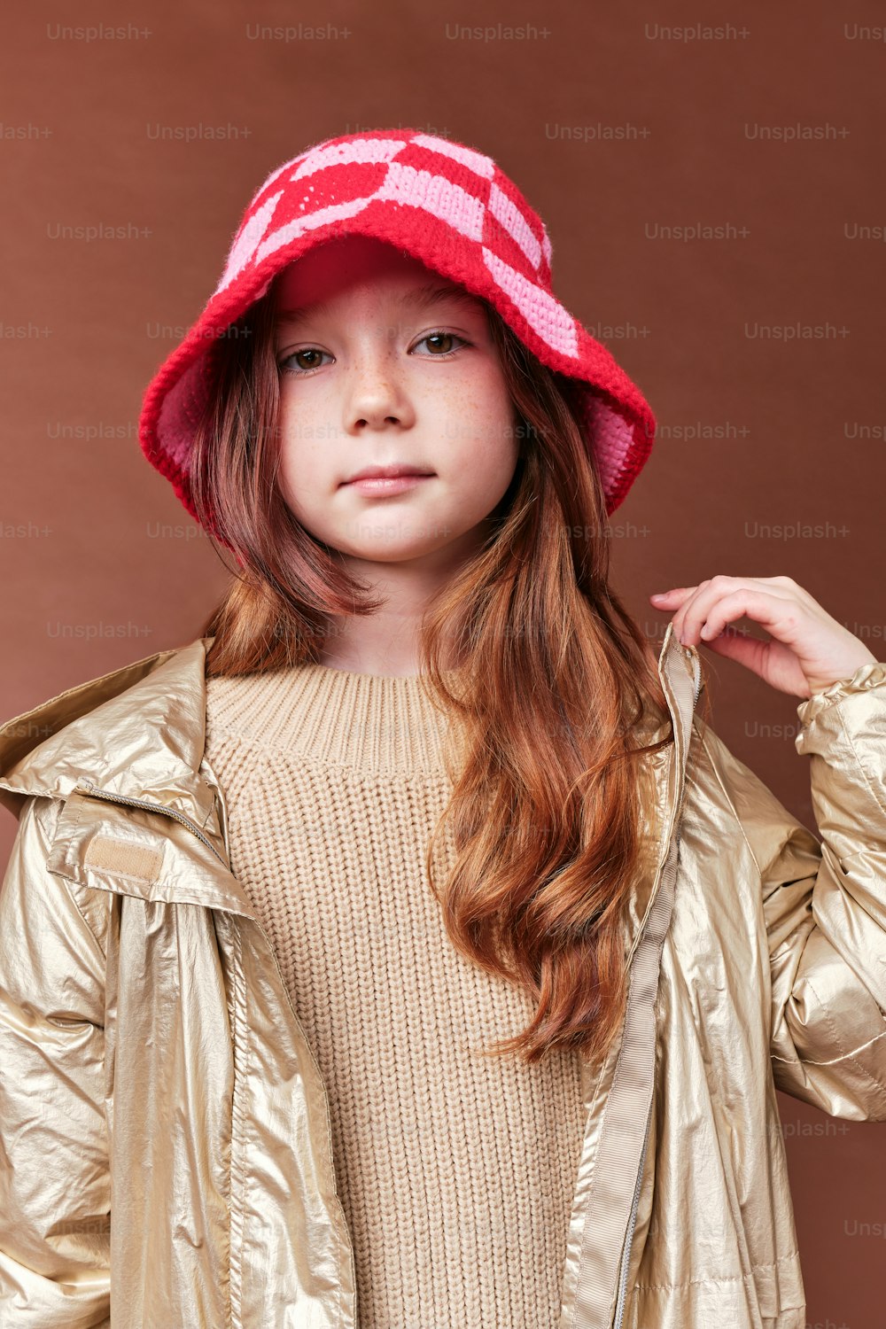 a young girl wearing a red hat and jacket